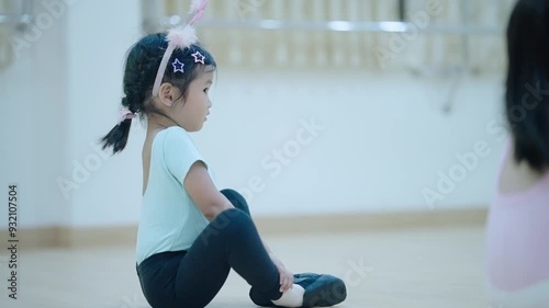 asian girl in jazz dance outfit sit down on the floor doing legs stretching warm up before practicing dance class, recreation for child, bond and muscles growth,  young girl learning jazz dance