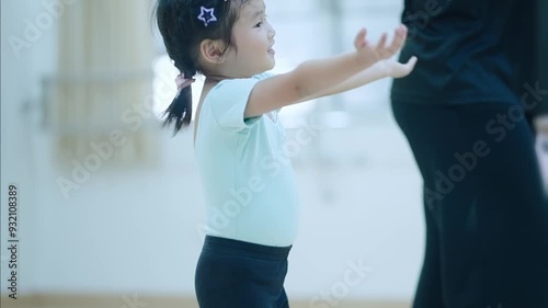 Adorable asian girl practicing in a dance studio classroom. Happy kid student in jazzdance outfir, learning a lesson of balancing choreograpy moves. Hobby Activity exercisenfor young chidren