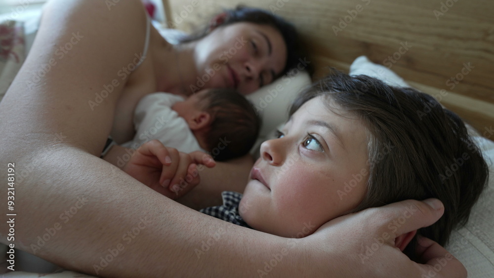 Mother and young son in bed, son looking thoughtful while mother and newborn sleep, early morning bonding, family togetherness, nurturing care, maternal affection, intimate and cozy moment Mother and young son in bed, son looking thoughtful while mother and newborn sleep, early morning bonding, family togetherness, nurturing care, maternal affection, intimate and cozy moment