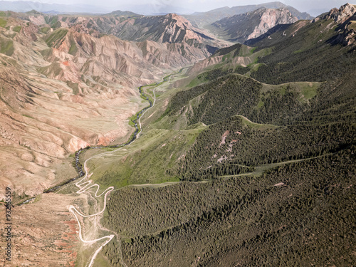 Aerial view of a winding mountain road curves, Kalmak Ashuu Pass, through lush greenery in Kyrgyzstan, Central Asia, Asia