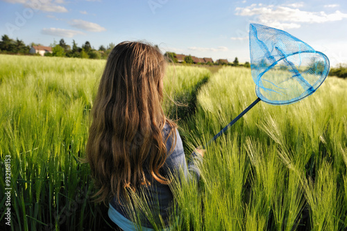 Little girl with a butterfly net in  field of  barley, Commune de Senantes, Departement d'Eure-et-Loir, Centre, France