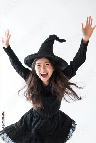 Dressed in a witch’s outfit with a pointy hat, a young woman’s confident smile embodies the mysterious and enchanting vibe perfect for Halloween celebrations. photo