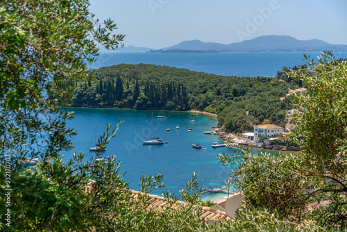 View of boats in the bay at Kalami with Corfu Town in background, Corfu, Ionian Sea, Greek Islands, Greece photo