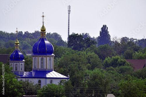 church. view of the Ukrainian church in the village. religion, Christianity. church holidays. crosses on the domes. no people. roofs of houses. summer or spring time. Orthodox temple. photo