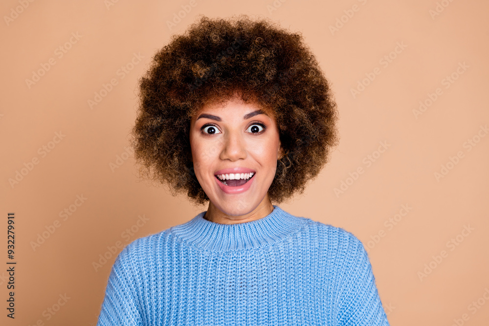 Photo portrait of young surprised american lady with brown hair chevelure in blue knitted sweater isolated on beige color background