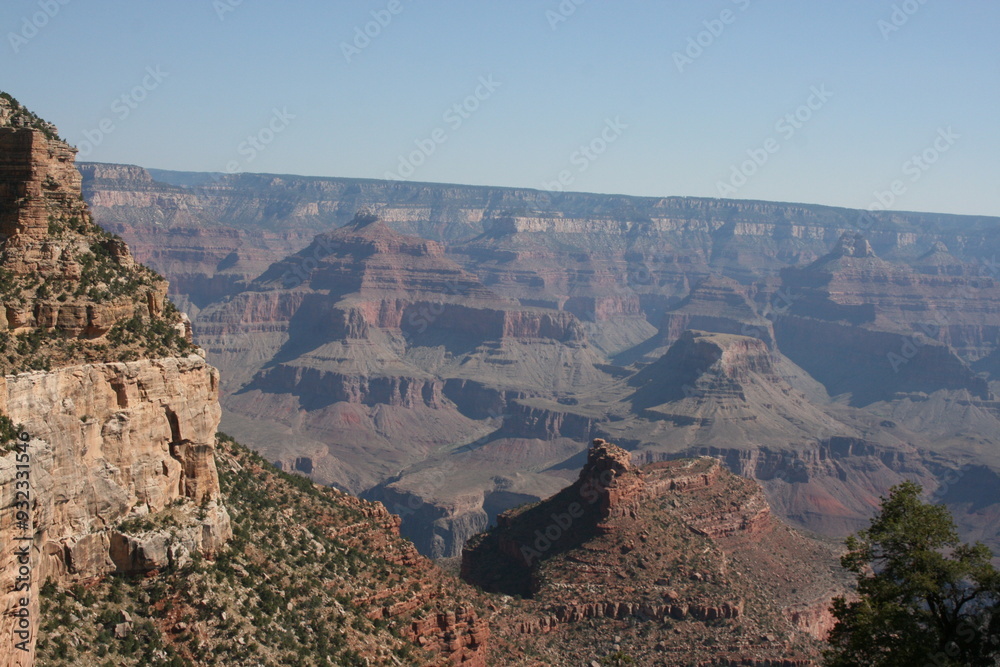 The Grand Canyon mountains under a clear sky, emphasizing the vastness and tranquility of the natural environment. The Grand Canyon mountains under a clear sky, emphasizing the vastness and tranquility of the natural environment.