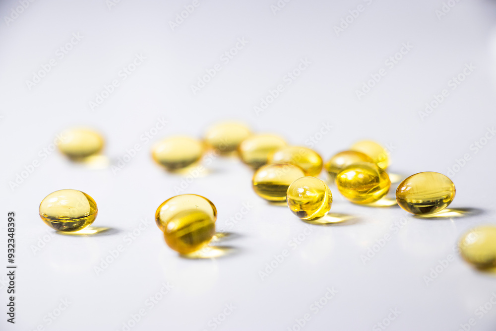 Yellow capsules lie on a white table. Vitamins D, Vitamin C, fish oil. Health prevention. Medicine