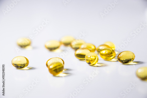 Obraz na płótnie Yellow capsules lie on a white table. Vitamins D, Vitamin C, fish oil. Health prevention. Medicine w salonie
