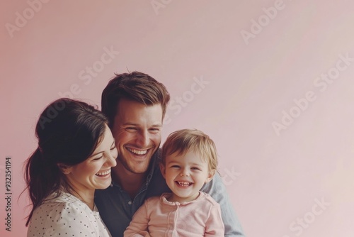 A happy family of three shares a joyful moment, smiling warmly while posing closely against a soft pastel background