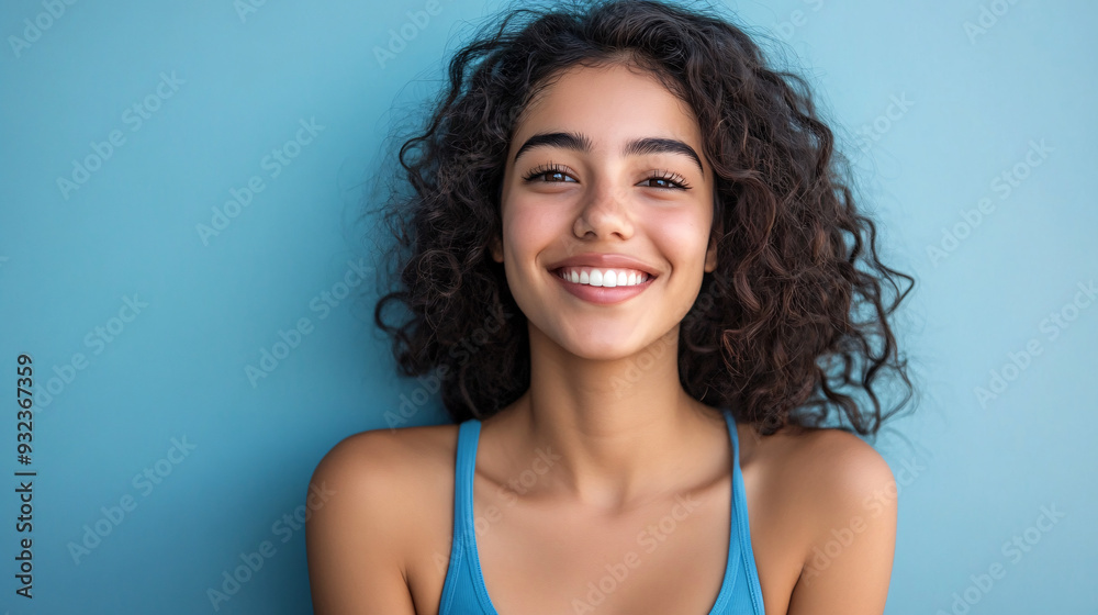 A cheerful Hispanic woman wearing a blue tank top, smiling, and isolated on a pastel background, suitable for lifestyle, fashion, and diversity concepts. A cheerful Hispanic woman wearing a blue tank top, smiling, and isolated on a pastel background, suitable for lifestyle, fashion, and diversity concepts.