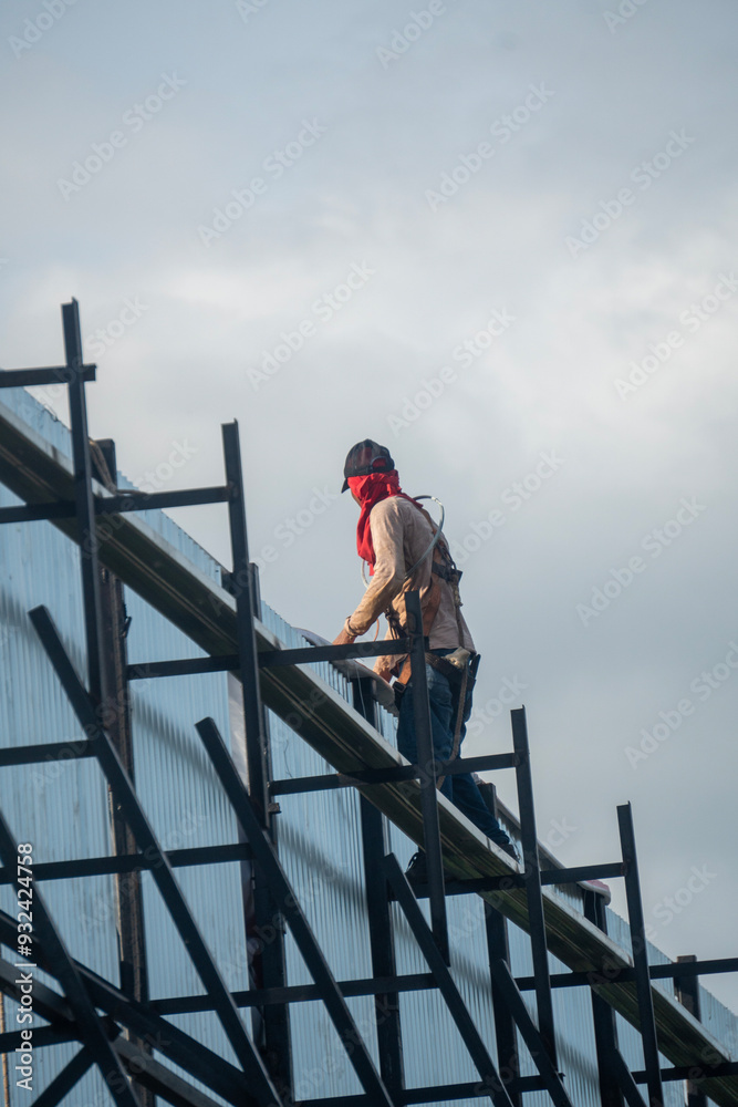 Worker performs maintenance on outdoor billboard structures Worker performs maintenance on outdoor billboard structures