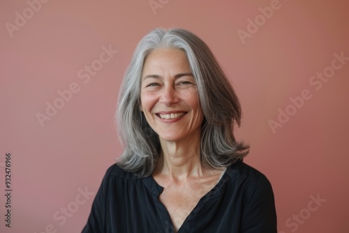 Wallpaper Mural An older woman with gray hair, smiling as she presents to an audience, standing against a solid color background, symbolizing her confidence and public speaking abilities Torontodigital.ca