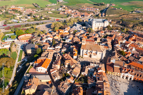 Scenic drone view of Simancas townscape overlooking main square Plaza Mayor, parish church of El Salvador and medieval fortified castle in background on sunny spring day, Valladolid province, Spain photo