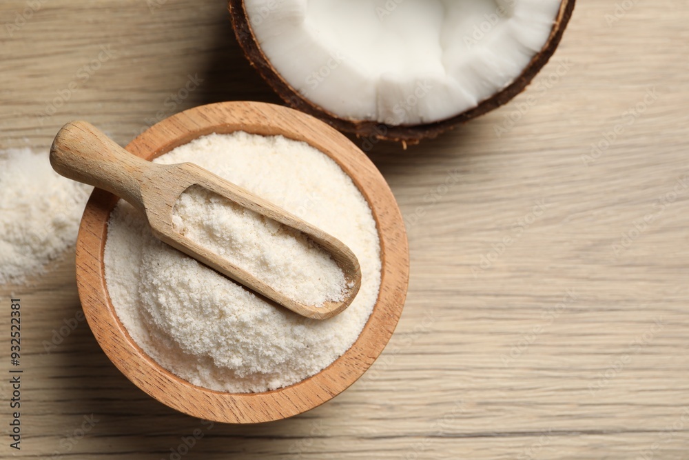 Fresh coconut flour in bowl, scoop and nut on wooden table, top view. Space for text Fresh coconut flour in bowl, scoop and nut on wooden table, top view. Space for text