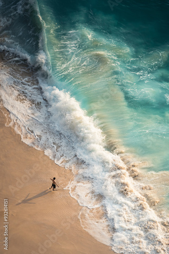 Fototapeta Naklejka Na Ścianę i Meble -  High angle aerial photography of huge waves and people on the kelingking beach in Penida, Bali, Indonesia