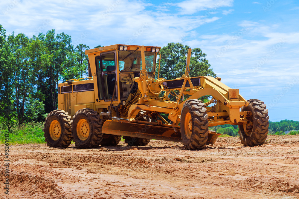 An earthmoving construction grader tractor at construction site An earthmoving construction grader tractor at construction site