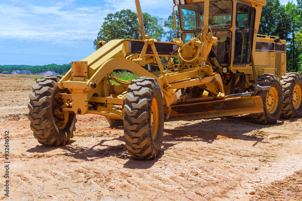 Heavy an earthmoving construction grader tractor with working at construction site Heavy an earthmoving construction grader tractor with working at construction site