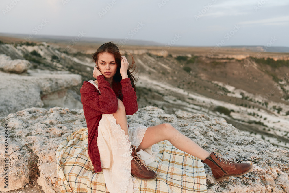 Adventurous woman enjoying mountain view in stylish red sweater and boots on cozy blanket Adventurous woman enjoying mountain view in stylish red sweater and boots on cozy blanket