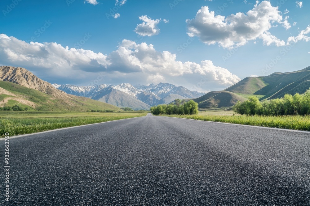 Fototapeta premium View of empty asphalt road with cloudy mountains on sunny day