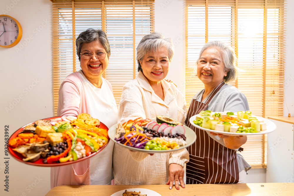 Group of Happy Asian senior women having dinner together at home. Elderly retired woman friends enjoy healthy lifestyle cooking and making vegan food vegetables salad with tofu together in the kitchen Group of Happy Asian senior women having dinner together at home. Elderly retired woman friends enjoy healthy lifestyle cooking and making vegan food vegetables salad with tofu together in the kitchen