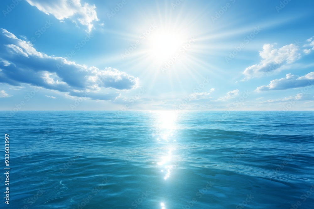 Obraz premium Serene Ocean with Clear Blue Waters and Bright Sunlight, Reflecting Light on the Horizon with Scattered White Clouds