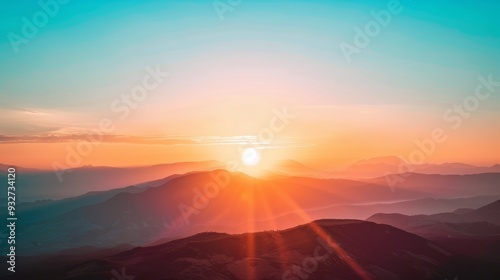 Radiant orange and pink hues fill the sky as the sun sets behind distant mountains, casting a warm glow over the landscape.