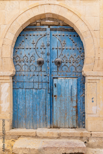 Kairouan, Tunisia. A blue door in a keyhole arch, also known as a Moorish Arch. photo