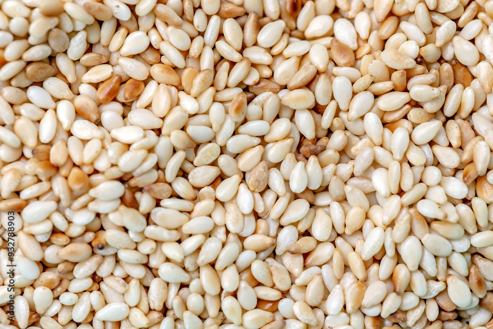 top view of background full of white sesame seeds. top view of background full of white sesame seeds.