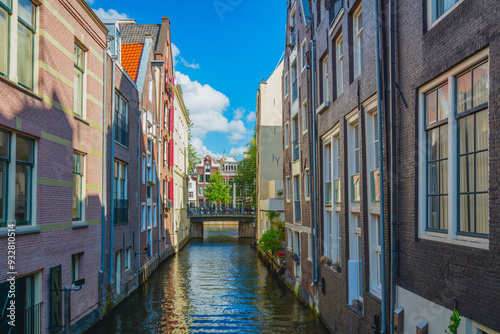 Unique Amsterdam - Narrow canal of Amsterdam with old traditional houses on the water. A beautiful sunny day.