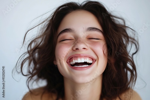 Young woman laughing with eyes closed, joyful expression