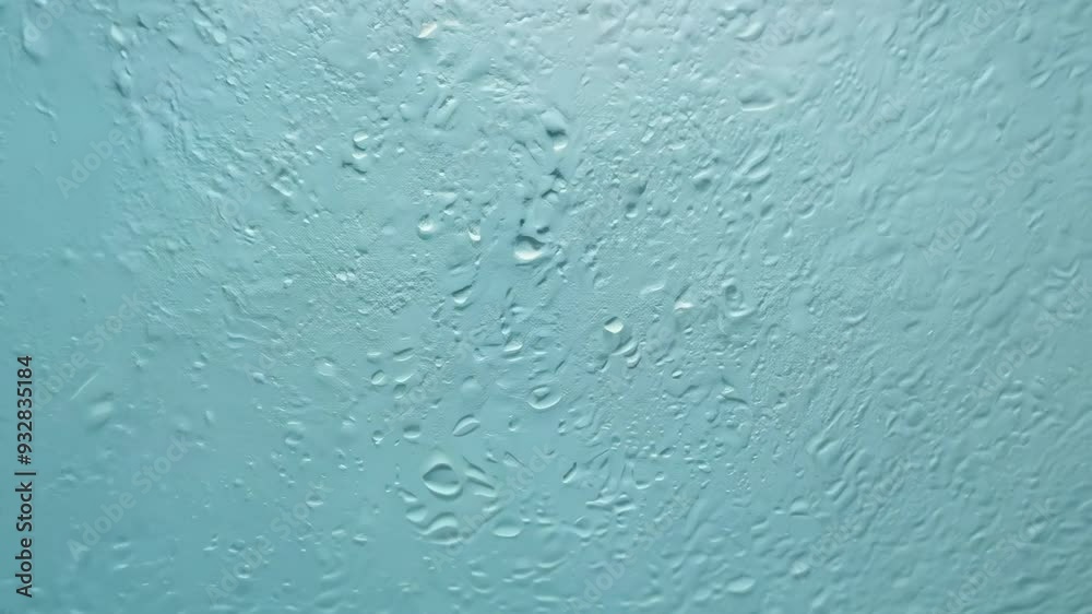 Raindrops trickling down a window on a cloudy day in a quiet neighborhood Raindrops trickling down a window on a cloudy day in a quiet neighborhood