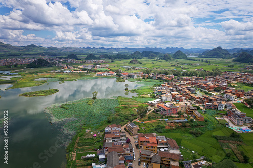 Drone view of colorful villages between rivers and mountain range in sunny cloudy day at Puzhehei, Yunnan, China. High angle view landscape of Chinese villages, travel concept, go everywhere. photo