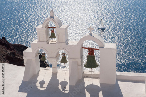 Greece, Santorini, Oia. View of church rooftop bells overlooking the Aegean Sea. photo