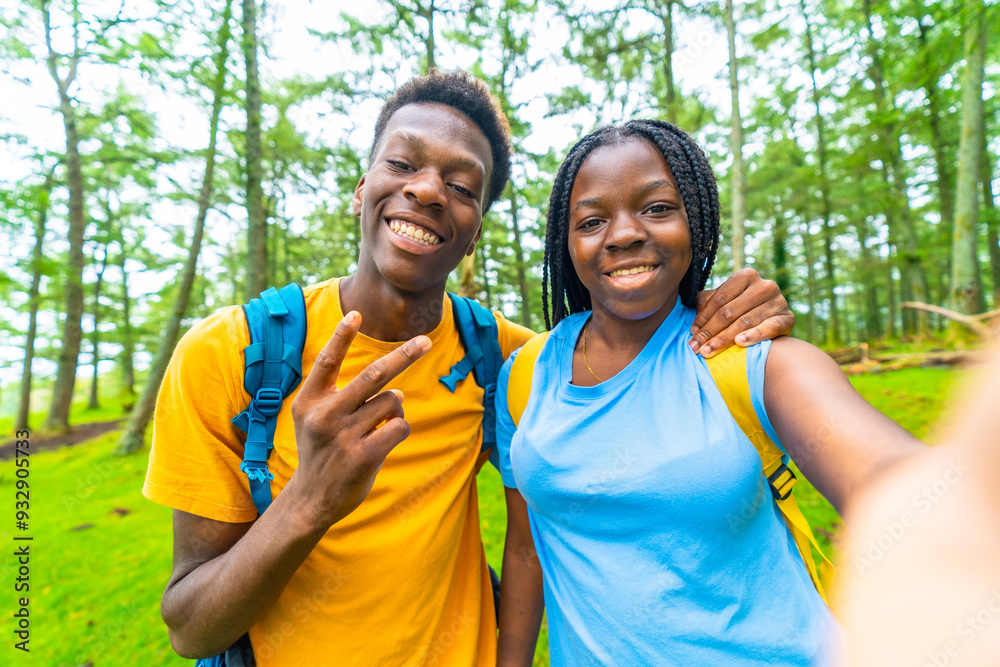 Friends gesturing victory with fingers while taking selfie hiking outdoors Friends gesturing victory with fingers while taking selfie hiking outdoors