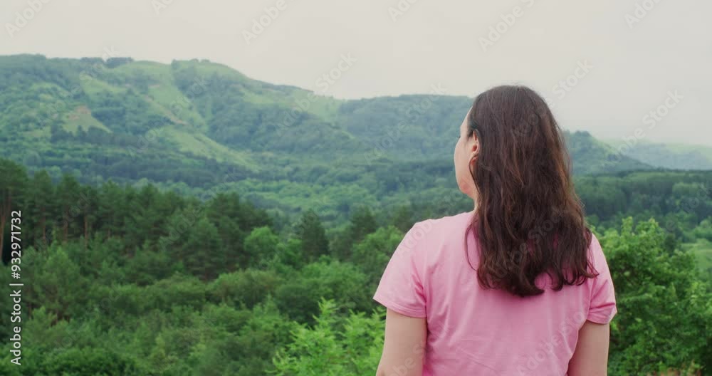 Rear view of female hiker looking at green mountain range. Woman is hiking valley against sky. She is spending leisure time during weekend. Rear view of female hiker looking at green mountain range. Woman is hiking valley against sky. She is spending leisure time during weekend.