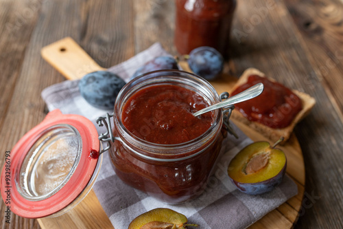 German plum butter or Pflaumenmus fresh and homemade cooked in a jar on wooden table background photo