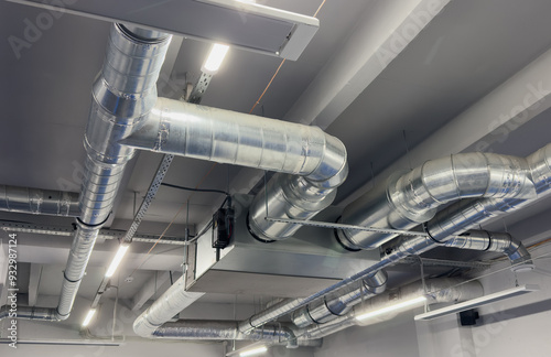 Konstfotografi Metal pipes in thermal insulation winding on the ceiling of an industrial enterprise