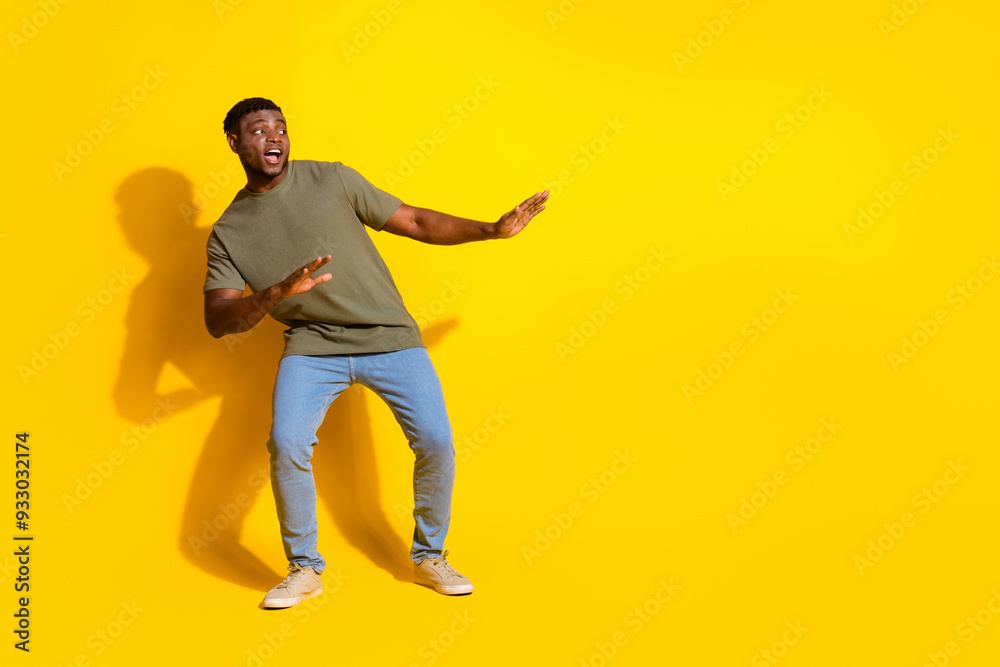 Photo of funny cheerful attractive man wear trendy khaki clothes empty space isolated on yellow color background Photo of funny cheerful attractive man wear trendy khaki clothes empty space isolated on yellow color background