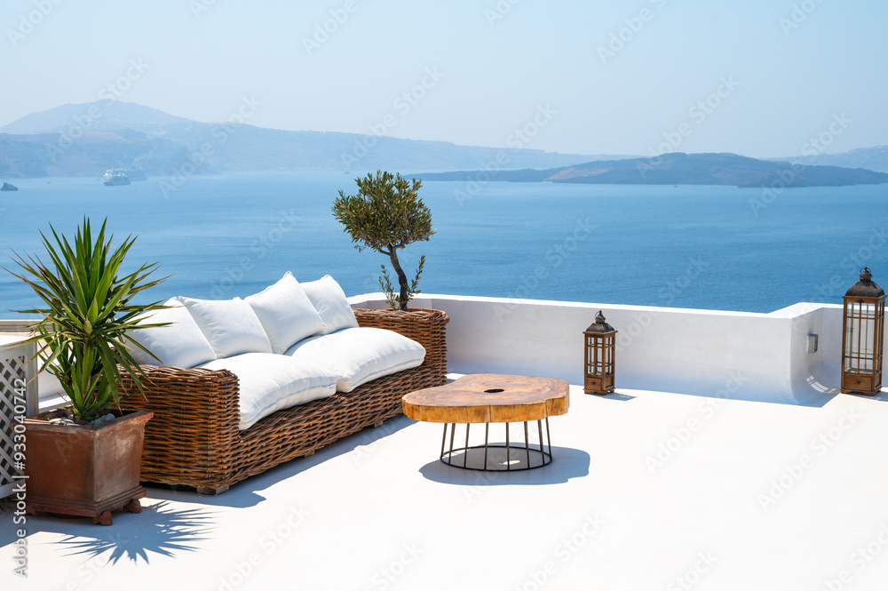 Summer terrace with rattan seat overlooking the sea. Oia, Santorini, Greece.