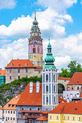 Wallpaper Mural The view showcases the historic Cesky Krumlov Castle Tower and the adjacent Bell Tower, set against a backdrop of vibrant blue skies and fluffy white clouds. Nestled atop a hill, the towers are Torontodigital.ca