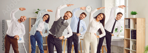 Happy young business people doing stretching sport exercises standing together in office. Group of smiling company employees exercising fitness for health during a break from a work. Banner. photo