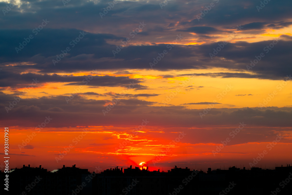 Sunset Sun in the Clouds over the City Rooftops Sunset Sun in the Clouds over the City Rooftops