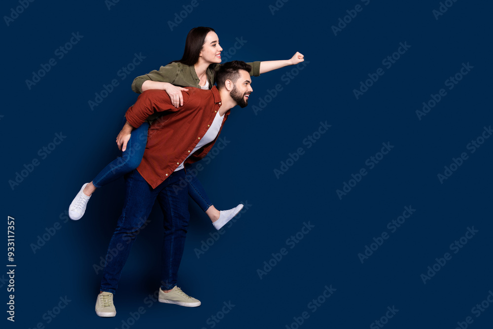 Profile side photo of cheerful crazy couple wear stylish clothes travel empty space isolated on dark blue color background Profile side photo of cheerful crazy couple wear stylish clothes travel empty space isolated on dark blue color background