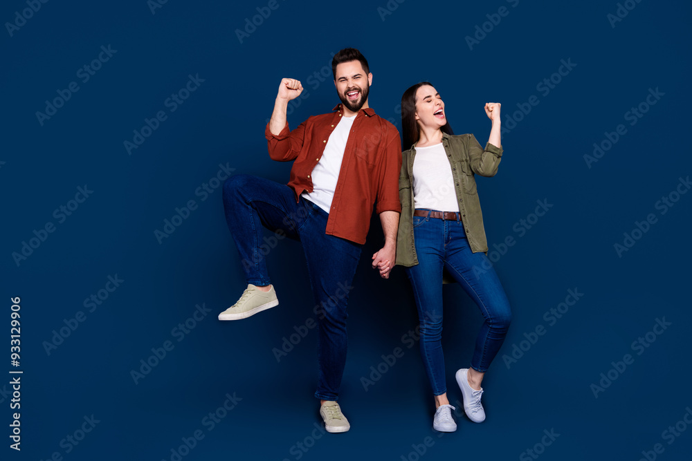 © deagreez - Photo of cheerful positive glad wife and husband wear stylish clothes yeah hooray sale isolated on dark blue color background © deagreez - Photo of cheerful positive glad wife and husband wear stylish clothes yeah hooray sale isolated on dark blue color background