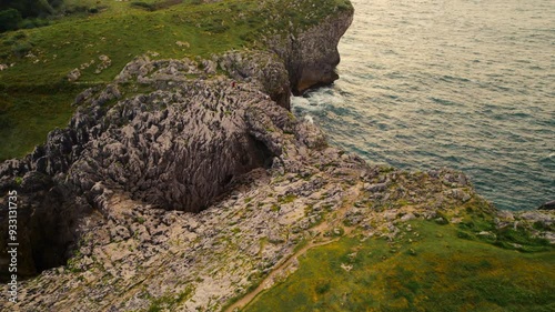 Aerial view of a scenic natural arch in a rocky coastline landscape in Llanes, Asturias, Spain. High quality 4k footage photo