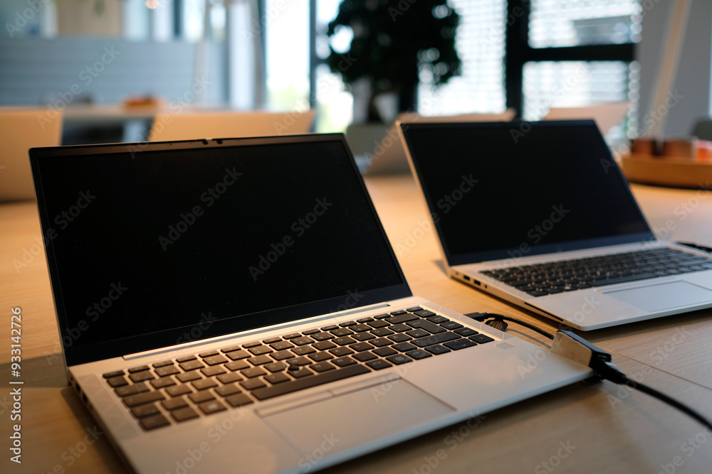 Laptops on a table in a co-working space Laptops on a table in a co-working space