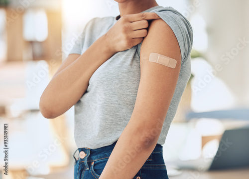 Woman, arm and vaccine with plaster for healthcare, cure or immunity in recovery at home. Closeup of female person with bandaid for covid vaccination, health protection or medical injection at house