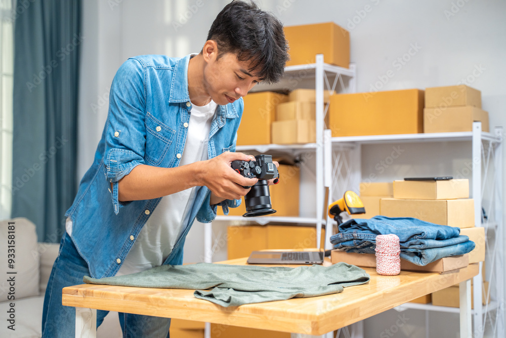 Young online seller man taking pictures of his shirt product to use on his website and online review at his home studio Young online seller man taking pictures of his shirt product to use on his website and online review at his home studio
