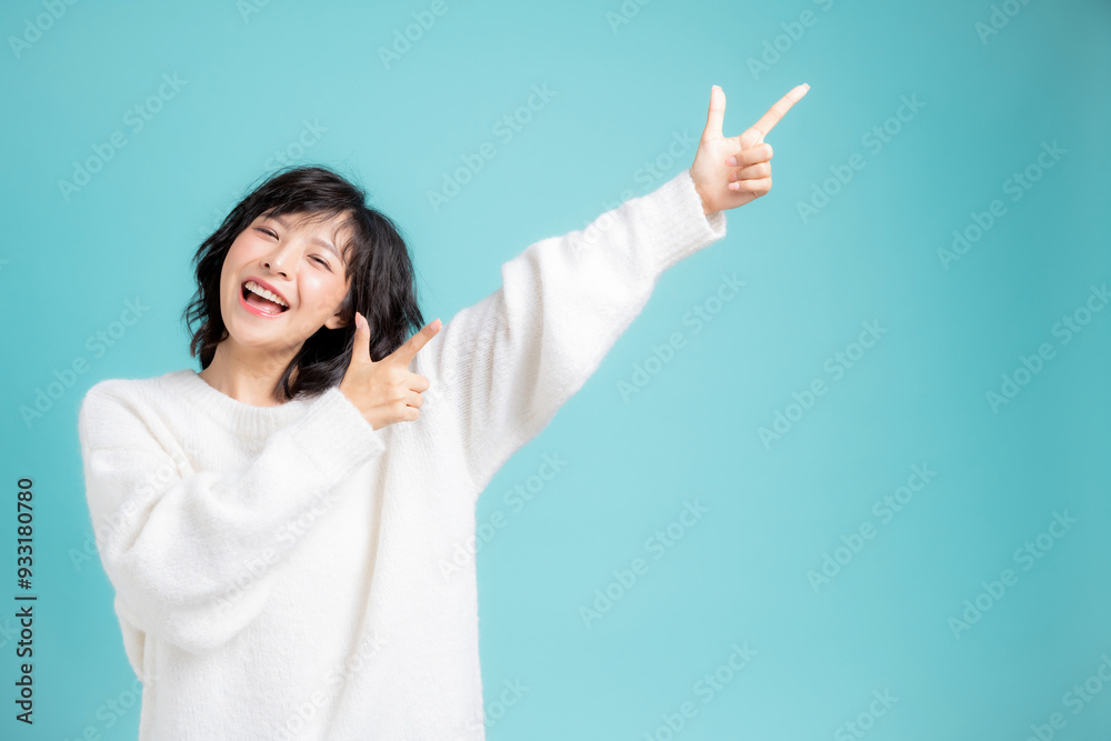 手をあげて指差しをしている若い女性 手をあげて指差しをしている若い女性