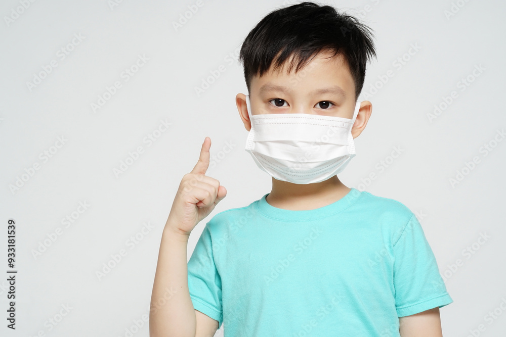 手でナンバーワンのサインをしているフェイスマスク姿の男の子の少年